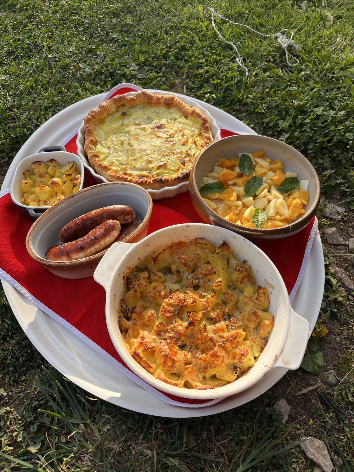Quiche aux poireaux, saucisses grillées, gratin dauphinois et salade de fruits